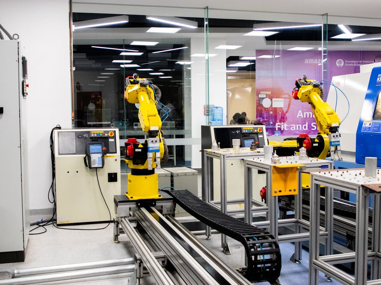 services-02 Robotic arms in action within a modern industrial control room setting, showcasing technology and production.