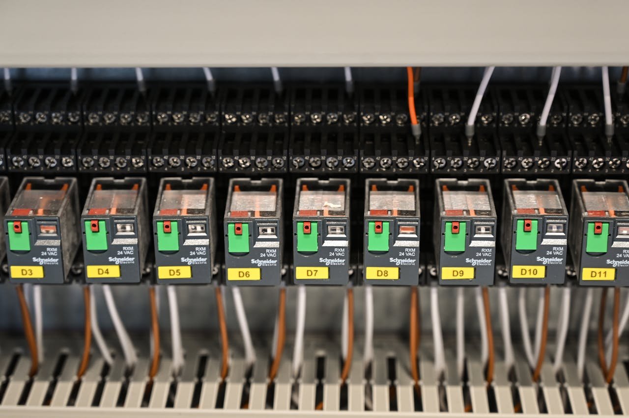 gallery-6 Close-up view of electrical relays in an industrial panel box showcasing circuit components.